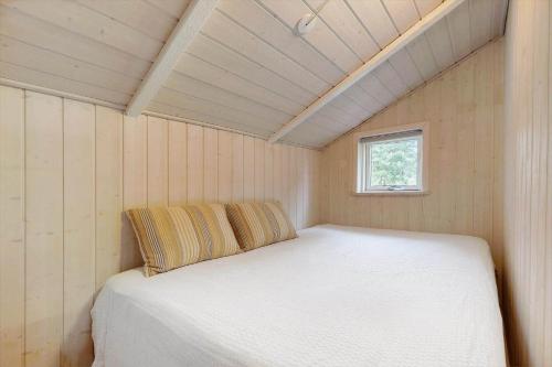 a bed in a small room with a window at 8834-Glesborg-Hemming-Nielsens-Vej-11 in Glesborg