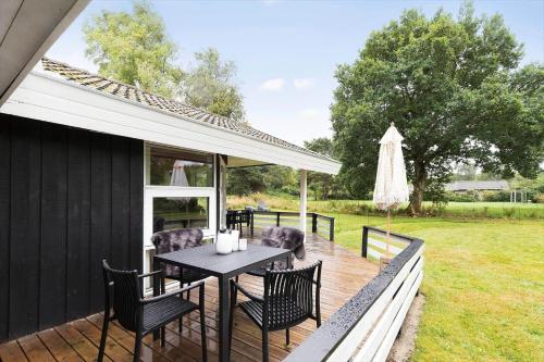 a wooden deck with a table and chairs at 8834-Glesborg-Hemming-Nielsens-Vej-11 in Glesborg