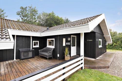 a black and white house with a wooden deck at 8834-Glesborg-Hemming-Nielsens-Vej-11 in Glesborg