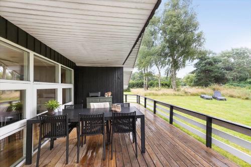 a patio with a table and chairs on a deck at 8834-Glesborg-Hemming-Nielsens-Vej-11 in Glesborg
