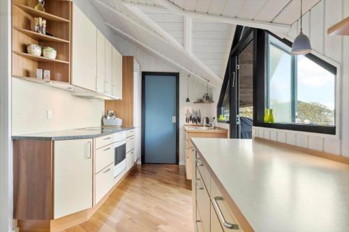 a large kitchen with white cabinets and a large window at 8924-Allingabro-Gyvelvej-26 in Allingåbro