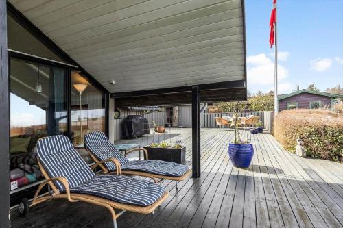 a deck with two chairs and a flag on it at 8924-Allingabro-Gyvelvej-26 in Allingåbro