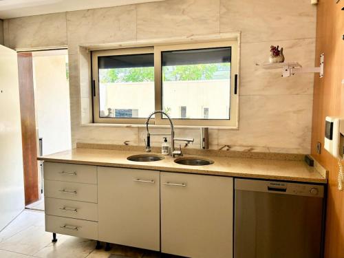 una cucina con due lavandini e una finestra di 5 Rooms Party Villa, 10 mins to Beach a Porto