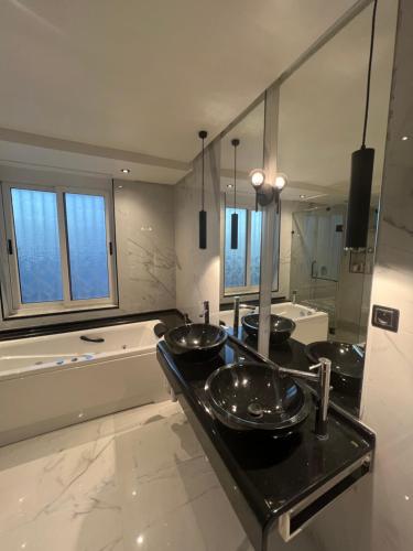 een badkamer met 3 wastafels en een bad bij Maison d'hôtes les berges du lac in Tunis