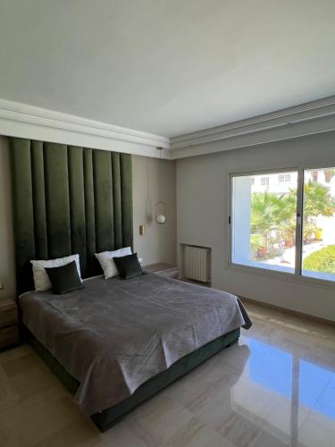 a bedroom with a large bed with a large window at Maison d'hôtes les berges du lac in Tunis