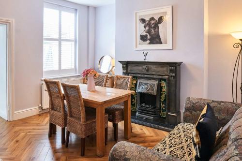 a dining room with a table and a fireplace at Host & Stay - Railway Cottages in Liverpool