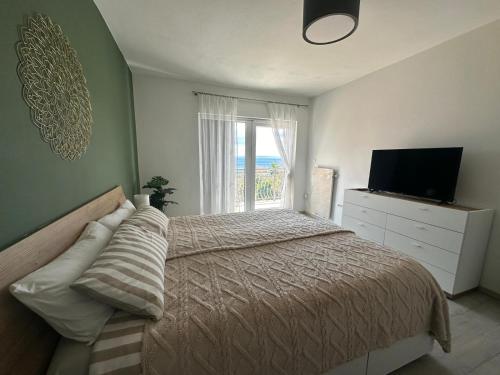 a bedroom with a bed and a television and a window at Villa Opic, ganze Villa, privater Pool, Meerblick, 4-8 Personen, 3 oder 5 Schlafzimmer in Opric