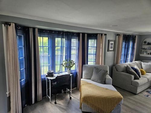 a living room with a couch and a table and windows at Peace of Mind Loft in Rochester