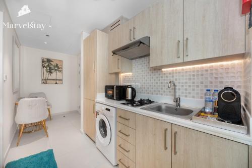 a kitchen with a sink and a washing machine at MarvelStay-Infinity Pool-Beachfront-The Palm in Dubai