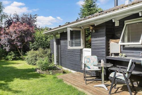 a house with a table and a chair on a deck at 1497-N-Gilleleje-Parcelvej-3 in Gilleleje