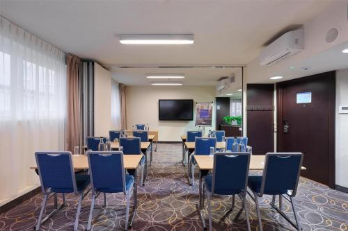a conference room with tables and chairs and a screen at Radisson Blu Sobieski in Warsaw