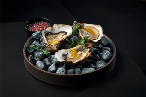 a bowl of oysters and berries on a black table at Radisson Blu Latvija Conference & Spa Hotel, Riga in Rīga