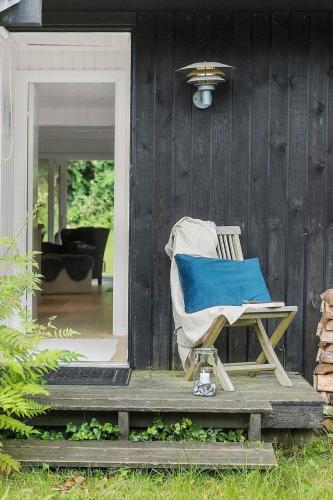 a rocking chair sitting on the porch of a house at 1587-Tisvildeleje-Stuebjergsvinget-3 in Tisvildeleje