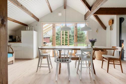 1619-Gilleleje-Ulvehojen-5 في جيليليه: مطبخ وغرفة طعام مع طاولة وكراسي