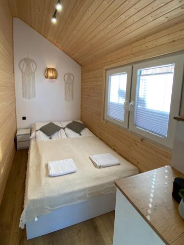a bedroom with a bed in a wooden room at Domki Przy Brzegu Chłapowo in Władysławowo