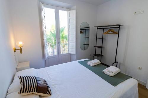 カディスにあるApartamentos La Cruz Verdeの窓のある大きな白いベッドのある寝室