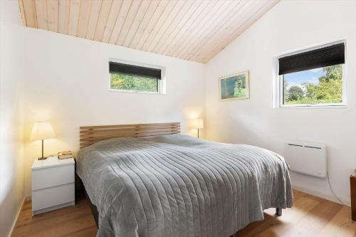 a white bedroom with a bed and two windows at 1586-Melby-Anna-Borgsvej-19 in Melby
