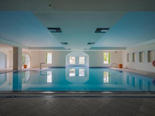 a large swimming pool with a blue ceiling at Aegean Melathron Thalasso Spa Hotel in Kallithea Halkidikis