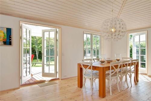 a dining room with a table and chairs and a chandelier at 902-N-Tisvildeleje-Klovervej-9 in Tisvildeleje
