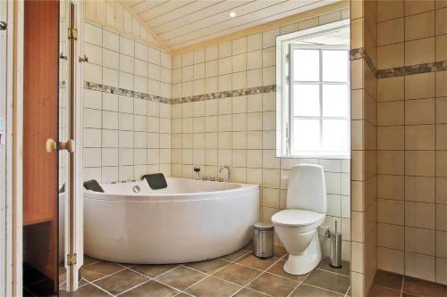 a bathroom with a white tub and a toilet at 902-N-Tisvildeleje-Klovervej-9 in Tisvildeleje