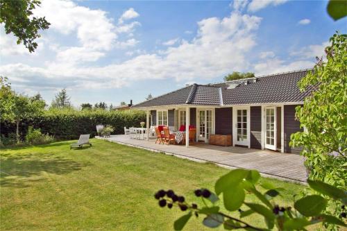 a house with a deck and a yard at 902-N-Tisvildeleje-Klovervej-9 in Tisvildeleje