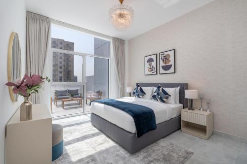 a bedroom with a large bed and a large window at Vogue Vacation Homes, Al Furjan Pearlz by Danube near Ibn Battuta Mall, One Bedroom Apartment with Terrace and vibrant community view, Access to all Amenities, Walkable to Al Furjan Metro Station in Dubai