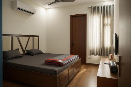 a bedroom with a bed and a television in it at 2BHK Luxury Villa In Mohali 1ST FLOOR - Stay Royal in Mohali