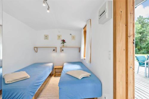 a small room with two blue beds on a porch at 725-N-Liseleje-Finsensvej-12 in Liseleje