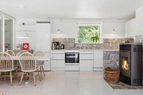 a kitchen with a fireplace and a table and chairs at 631-N-Melby-Ved-Hojen-19 in Melby