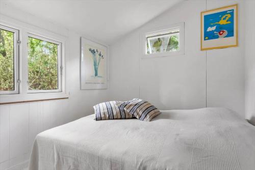 a white bedroom with a bed and two windows at 1646-Hornbaek-Nordre-Strandvej-412 in Hornbæk