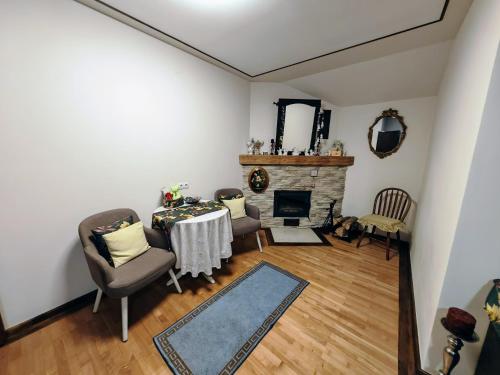 a living room with a table and chairs and a fireplace at CASA DE SUB MAGURA in Simeria