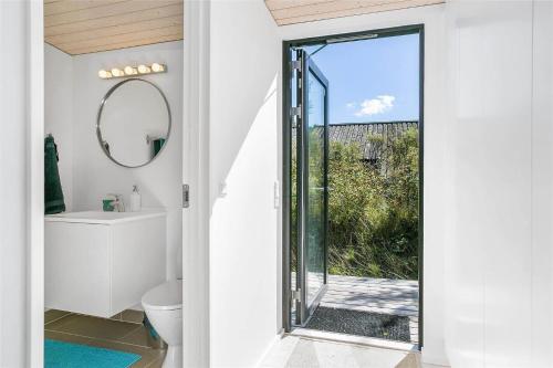 a bathroom with a toilet and a glass door at 1164-N-Melby-Bjergvej-7 in Melby