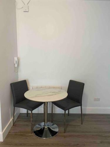 a table and two chairs in a room at Dream Yard Apartments in Southend-on-Sea