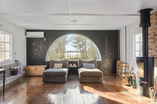 een woonkamer met een bank en een open haard bij 1639-Frederiksvaerk-Genvejen-10 in Frederiksværk