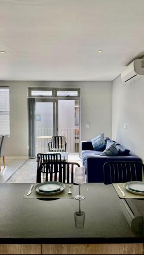 a living room with a bed and a table with plates on it at The Madge Self Catering in Paarl