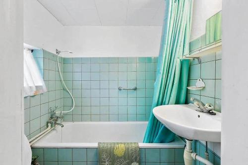 a blue tiled bathroom with a sink and a tub at 1102-N-Hundested-Skansevej-45 in Hundested