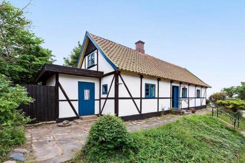 a white house with blue doors and a fence at 1102-N-Hundested-Skansevej-45 in Hundested