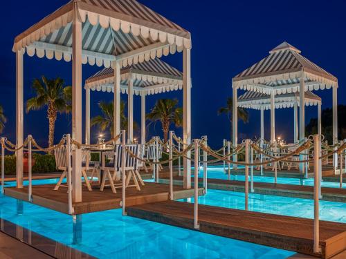 a rendering of a resort pool with a slide and gazebo at Aegean Melathron Thalasso Spa Hotel in Kallithea Halkidikis