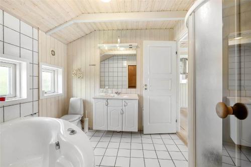 a bathroom with a tub and a toilet and a sink at 617-N-Melby-Bakkely-8-B in Melby