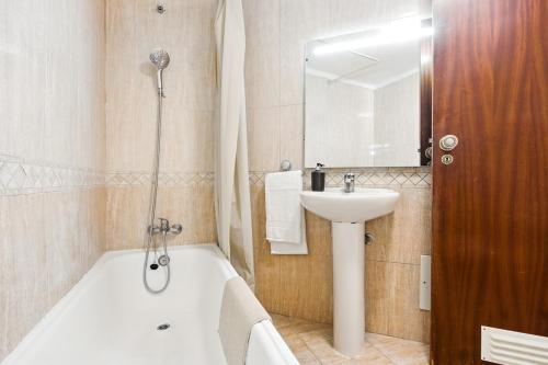 a bathroom with a tub and a sink and a bath tub at T2 Apartment near the beach in Albufeira