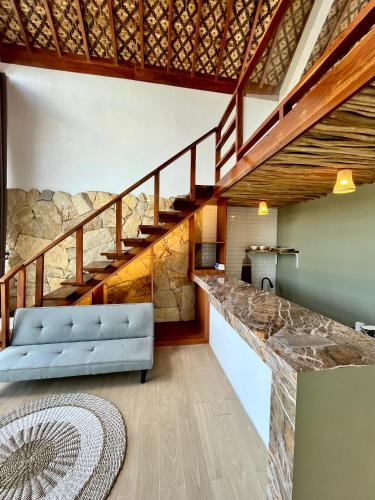 a living room with a blue couch and a staircase at Villa Suaka by Sackstone in Watukarung