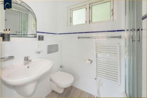 a white bathroom with a toilet and a sink at Ferienanlage Bansin Seepferdchen 3 in Bansin