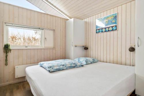 a bedroom with a white bed in a room with a window at 1627-Dronningmolle-Svalevej-3 in Dronningmølle