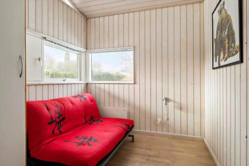 a red couch in a room with a window at 1627-Dronningmolle-Svalevej-3 in Dronningmølle