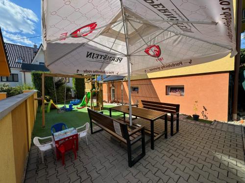 a patio with a table and chairs and an umbrella at Apartmany Hujer in Bojnice