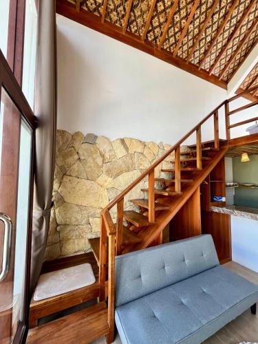 a staircase in a room with a stone wall at Villa Suaka by Sackstone in Watukarung