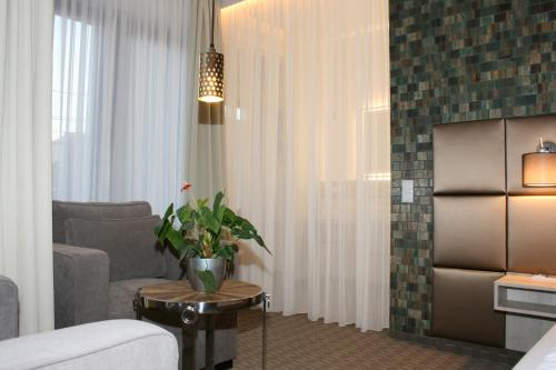 a living room with a couch and a table with a plant at Landhotel Rittmeister & Kräuter-SPA Adults Only in Rostock