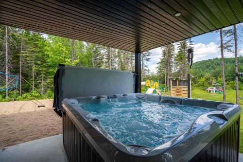 a jacuzzi tub on a patio with a view at LAKE and SPA - Le Matit 21 in Saint Come
