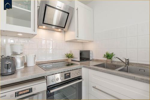 a white kitchen with a sink and a stove at Ferienanlage Bansin Seepferdchen 5 in Bansin