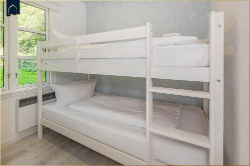 a bunk bed with white bunk beds in a room at Ferienanlage Bansin Seepferdchen 5 in Bansin
